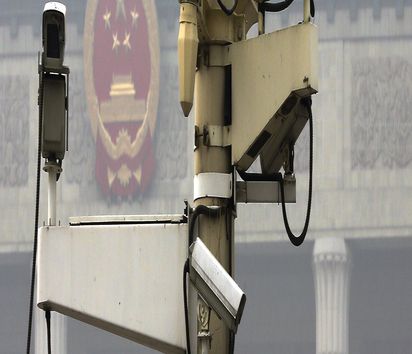 A pole attached with security cameras to monitor Tiananmen Square stands against a backdrop of the Chinese Communist Party emblem on the Great Hall of the People shrouded by thick haze in Beijing, China Monday, Oct. 20, 2014. The conundrum of bolstering rule of law in Communist Party-run China was on the agenda for the ruling party's top leaders Monday as they opened a four-day conclave to guide policy for the coming year. (AP Photo/Andy Wong) || Nur für redaktionelle Verwendung