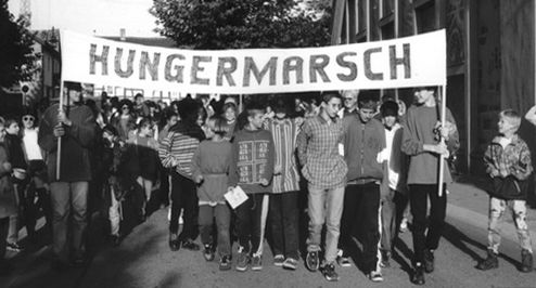 Schwarz-weiß Aufnahme von Demonstrierenden mit einem Banner auf dem "Hungermarsch" steht