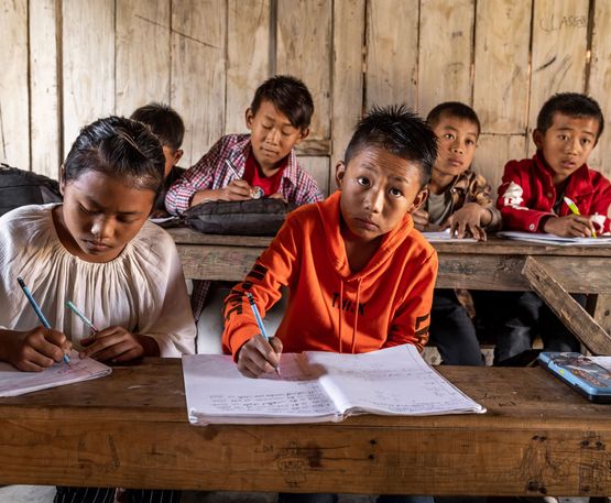 Sechs Kinder beim schreiben in der Dorfschule