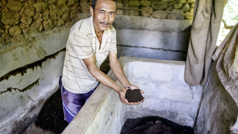 Shankhar Bhujal steht in einem Raum und zeigt fertigen Bio-Kompost