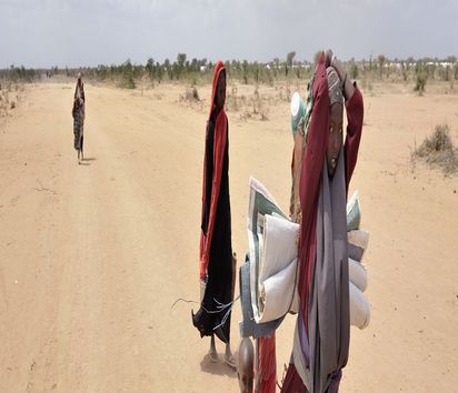 Habiba Ibrahim Ali ist 20 Jahre alt und aus Somalia geflohen. Sie läuft mit anderen Frauen und ihren Kindern in den erweiterten Teil des Flüchtlingslagers Dadaab Zehntausende Menschen fliehen vor der Dürre und dem Krieg in Somalia nach Dadaab, das größte Flüchtlingslager der Welt, in Kenia.  Das Flüchtlingslager Dadaab wurde mit dem nicht abrechenden Flüchtlingsstrom zu klein, so dass es am 25. Juli noch weiter vergrößert wurde.