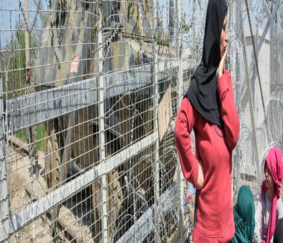 Demonstration an der grieschisch-mazedonischen Grenze im Flüchtlingslager Idomeni (Griechenland) am 07.04.15. Grieschische Polizisten (blaue Uniform) schützen einen kurzen Streifen Bahngleise noch auf der griechischen Seite den Frauen und Kinder besetzen während mazedonischen Soldaten mit gepanzertem Fahrzeug auf der anderen Seite die Lage beobachten. 10000 bis 15000 Menschen leben derzeit hier schon zum teil seit Monaten und werden von UNHCR, Freiwilligen und Nichtregierungsorganisationen versorgt.