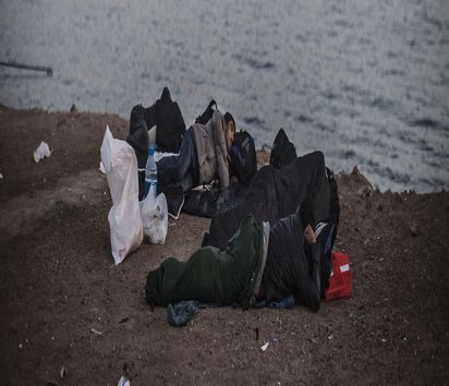 GRC, Griechenland, Chios, 30.09.2015: Gerade angekommene umidentifizierte Flüchtlinge schlafen am Strand nahe des Hafens von Chios Town. Der Leiter der Diakonie Katastrophenhilfe, Martin Kessler ist auf einem Kurzbesuch auf der Insel Chios um sich ein Bild der Lage der dort ankommenden Flüchtlinge zu machen und um Mitarbeiter von Parteiorganisationen zu treffen. Chios ist nur 7 km von der Türkischen Küste entfernt und jeden Tag erreichen Schlauchboote die Insel. Nach Zählung der lokalen Polizei allein allein im September 2015 über 13.000.(Hermann Bredehorst/ Diakonie Katastrophenhilfe)