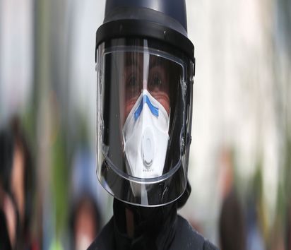 Ein Polizist mit Mundschutz und Einweghandschuhe geht in des Rosa-Luxemburg-Platz bei einer Kundgebung gegen die Corona-Einschränkungen. Verschiedene Kundgebungen finden auf dem Rosa-Luxemburg-Platz statt. Zu einer der Kundgebungen hatte eine Gruppe mit dem Namen «Demokratischer Widerstand» aufgerufen, die bereits in den vergangenen Wochen mehrere ähnliche Kundgebungen veranstaltet hat. || Nur für redaktionelle Verwendung