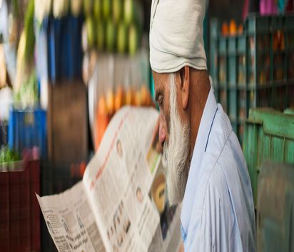 Ein Mann liest am 18.10.2015 auf einem Markt in Munnar (Indien) eine Zeitung. Foto: Sebastian Kahnert || Nur für redaktionelle Verwendung