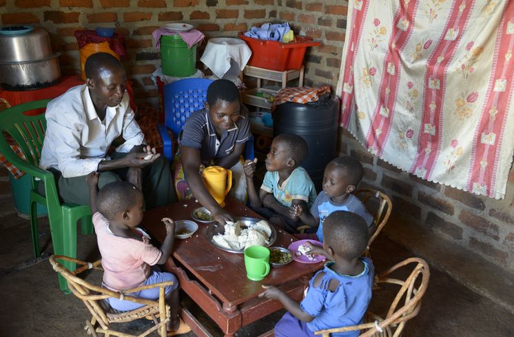 TANSANIA, Tarime Distrikt, MFEC - Mogabiri Farm Extension Centre, Dorf Kewamaba, Hof von Isaya Mwita, 34 Jahre, und seiner Frau Grace, 23 Jahre, im Bild Isaya und Grace mit Kindern beim Mittagessen