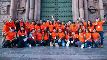 Gruppenfoto auf Treppen vor eine Kirche, alle tragen orangene Brot für die Welt T-shirts