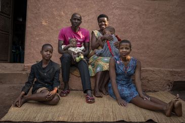 Joy Kamusiime (38), ihr Ehemann Kamugisha (45), ihr jüngster Sohn John Levison Kamugiso (3 Monate), Immaculate Amatwire (13, rechts), Sheeran Akampulira (3, 2. von rechts) und Davis Tusiime (10, links) in ihrem Haus im Dorf Kikunda 1 im Distrikt Rwampara.Projektpartner: ACORD - Agency for Cooperation in Research and Development