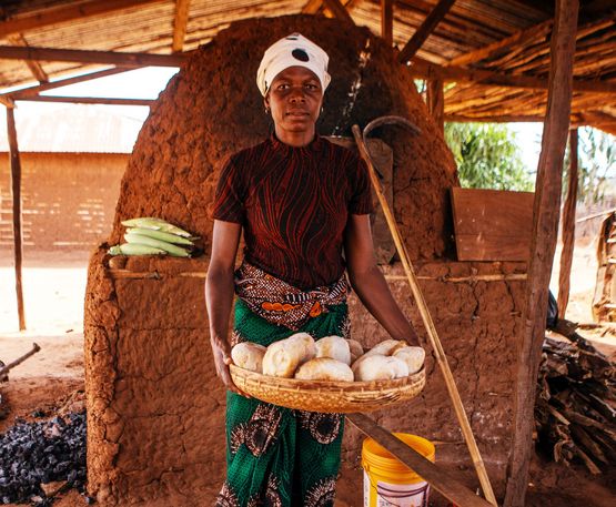 Tima Lopes Faita, 40, im Flüchtlingscamp Corrane neben ihrem Ofen am 6. Oktober 2025.Die Fischerin Tima Lopes hat Krieg und Flucht überlebt. Heute backt sie in ihrer neuen Heimat Brot – und versorgt ihre Familie und das ganze Dorf.Projektpartner: CEDES