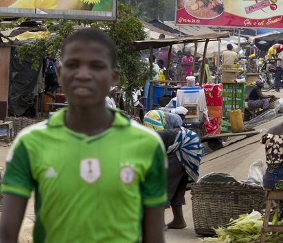Am Rande eines Marktes in der togolesischen Hauptstadt Lome wird auf großen Werbetafeln für importierte Lebensmittel geworben.