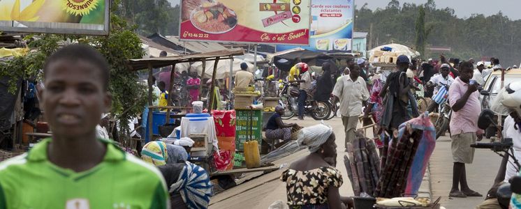 Am Rande eines Marktes in der togolesischen Hauptstadt Lome wird auf großen Werbetafeln für importierte Lebensmittel geworben.