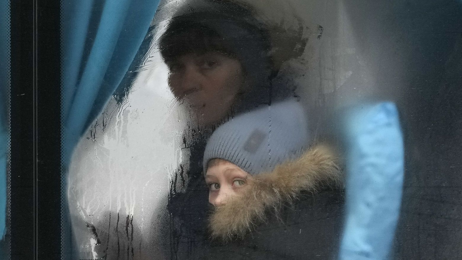 Flüchtlinge aus der Ukraine schauen aus einem Bus