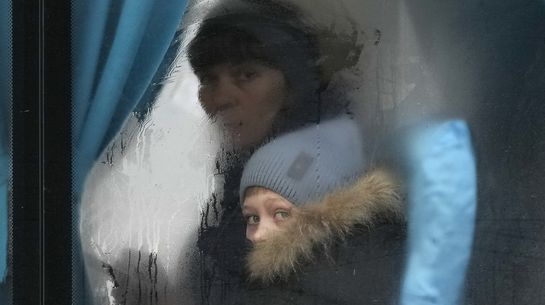 Flüchtlinge aus der Ukraine schauen aus einem Bus