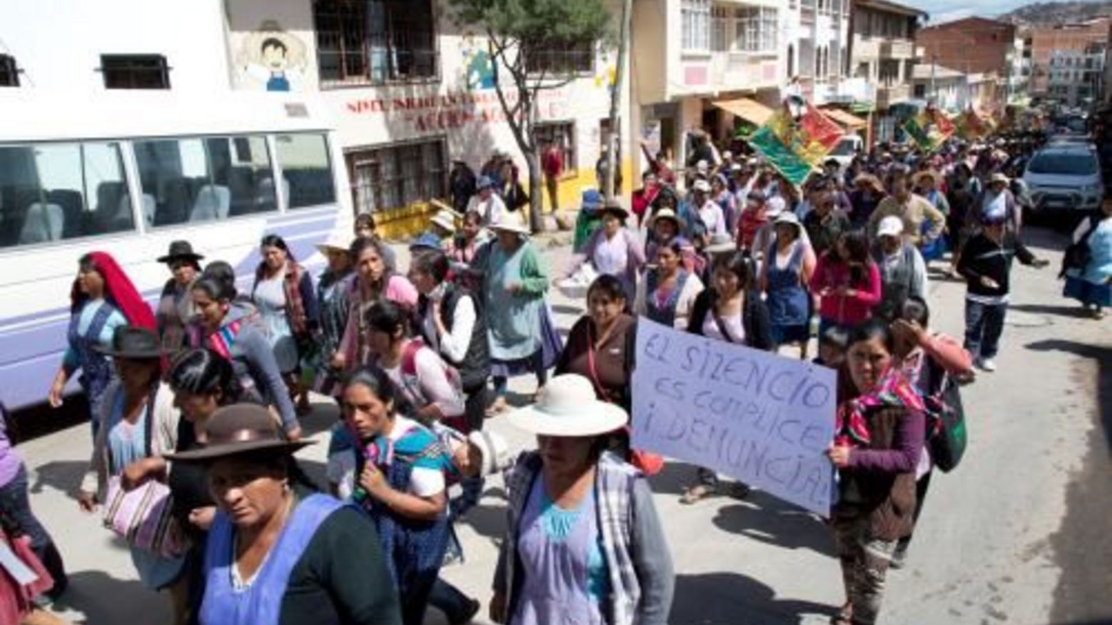 Das Bild zeigt Frauen in Sucre, Bolivien, die in einem Protestmarsch gegen gewalt gegen Frauen durch eine Straße ziehen
