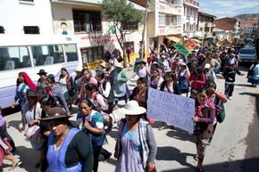 Das Bild zeigt Frauen in Sucre, Bolivien, die in einem Protestmarsch gegen gewalt gegen Frauen durch eine Straße ziehen
