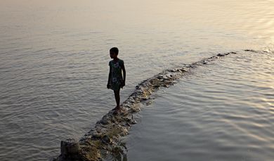 Kind am Ufer in Shyamnagar, Bangladesch
