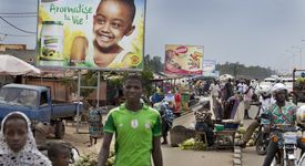 Ausland, Afrika, Westafrika, Togo, Ressourcen, Ernährung, Ernährungssicherheit, Nahrung, Lebensmittel, Nahrungsmittel, Grundnahrungsmittel, Landwirtschaft, Kleinbauern, Roherzeugnis, Verbraucher, Konsument, Ausland, Europa, Importprodukt, Werbung, Werbeplakat, Marktbesucher, Marktstand, Mann, Straße, Markt, Plakat, Verkehr