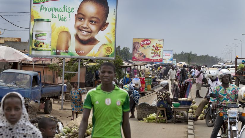 Ausland, Afrika, Westafrika, Togo, Ressourcen, Ernährung, Ernährungssicherheit, Nahrung, Lebensmittel, Nahrungsmittel, Grundnahrungsmittel, Landwirtschaft, Kleinbauern, Roherzeugnis, Verbraucher, Konsument, Ausland, Europa, Importprodukt, Werbung, Werbeplakat, Marktbesucher, Marktstand, Mann, Straße, Markt, Plakat, Verkehr