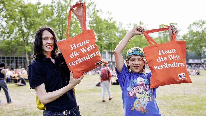 Junge Kirchentagsbesucher mit „Brot für die Welt“ Beutel: Heute die Welt verändern