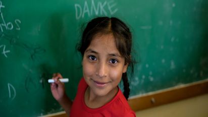 Orozas Norte, Padcaya, Bolivien. Anabel, eine Schülerin der lokalen Grundschule, schreibt eine Danke-Nachricht an die Tafel in ihrem Klassenzimmer. Projektpartner: Acción Cultural Loyola (ACLO)