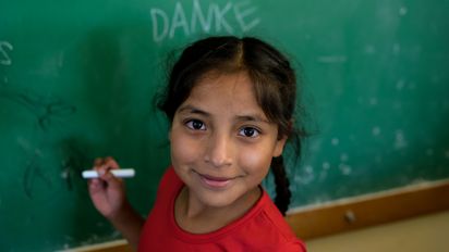 Orozas Norte, Padcaya, Bolivien. Anabel, eine Schülerin der lokalen Grundschule, schreibt eine Danke-Nachricht an die Tafel in ihrem Klassenzimmer. Projektpartner: Acción Cultural Loyola (ACLO)
