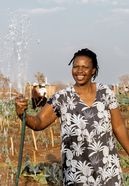 Beauty Nyathi (45) wässert ihr Feld im Community-Garten.Partnerorganisation: Consorcio