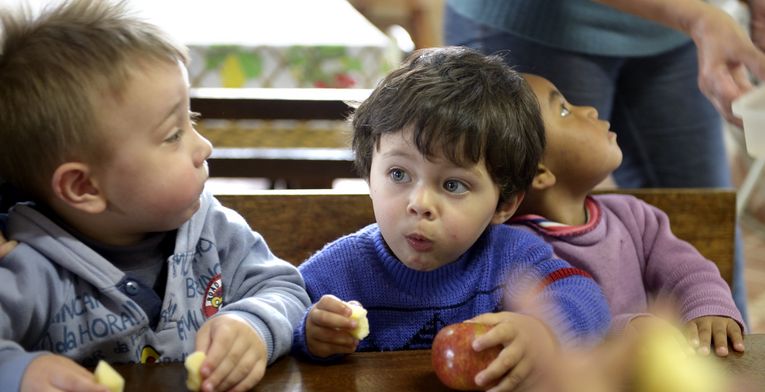 Derick Coutinho, 2 Jahre, ißt einen Apfel aus ökologischen Anbau, Kindergarten der Gemeinde Cangucu "Branca de Neve" (Schneewittchen), Cangucu, Rio Grande do Sul, Brasilien; Foto: Florian Kopp / Brot für die Welt