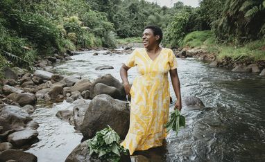 Luisa Curuki (35) Vorsitzende Womens‘ Club, waescht Bele-Blaetter im Fluss hinter ihrem Haus.Der Partner von Brot fuer die Welt, FCOSS (Fiji Council of Social Services) unterstuetzt die Umsiedlung des Dorfes Cogea. Cogea wurde vom Zyklon "Yasa" Ende 2020 zerstoert.