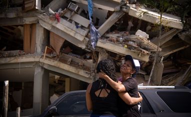 Zwei Menschen vor Trümmern eines Hauses in Venezuela