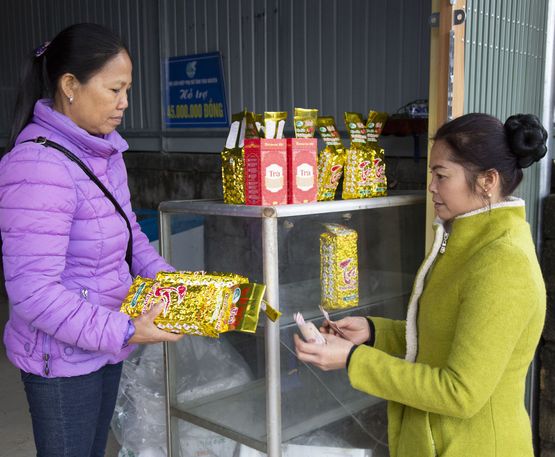 Teeproduzentin Mai Nguyen Thi verkauft ihren Tee an eine Frau