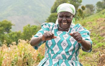 Mary Lagat aus Kenia steht lachend auf einem Feld.