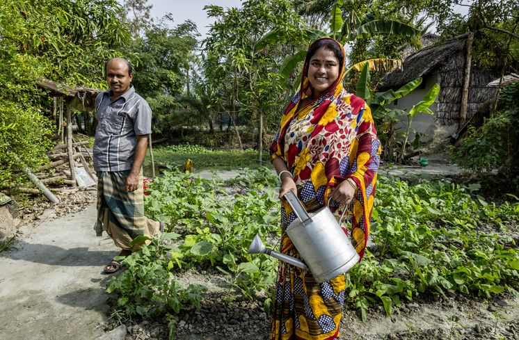 CCDB Bangladesch Baeuerin und Mutter Suparna Raptan holt taeglich Wasser von der ein Kilometer entfernten CCDB Wasserstelle Vamia nach Hause, wo sie mit ihrem Mann Utpol Raptan, im ihrem Garten Gemuese anbauen. Die Menschen in den kleinen Siedlungen an den Fluessen in der Naehe von Shyamnagar in Sued Bangladesch, spuehren deutlich den Klimawandel. Der Meeresspiegel steigt und Daemme werden zerstört. Da durch werden Felder und die wichtigen Suesswasserteiche ueberflutet und versalzen. CCDB Bangladesch arbeitet an Suesswassergewinnungs-Projekten und sorgt dafuer, dass die Menschen nach und nach sauberes Trinkwasser erhalten.