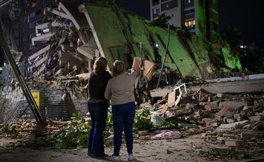 Fanny Nasri waits at the site of a collapsed building as emergency workers search for her son, Antonio Nasri, alongside Noemi Cordoba, who awaits news of her granddaughter, after an earthquake in Caracas, Venezuela, June 25, 2026. REUTERS/Gaby Oraa