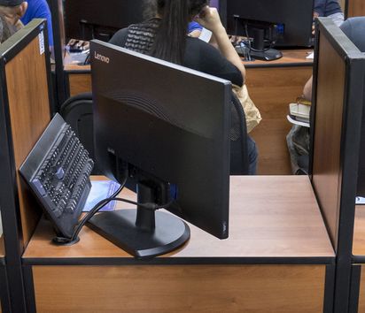 Raum voll Computerarbeitsplätzen an denen Mitarbeitende Daten Abgeschobenen aufnehmen