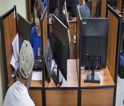 Raum voll Computerarbeitsplätzen an denen Mitarbeitende Daten Abgeschobenen aufnehmen