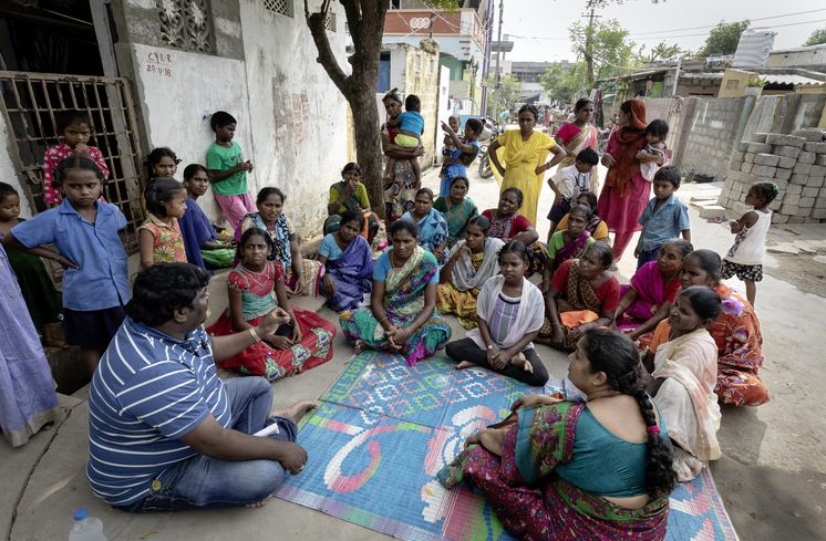 Menschengruppe sitzt in Indien im Kreis