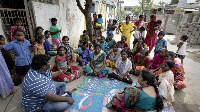 Menschengruppe sitzt in Indien im Kreis