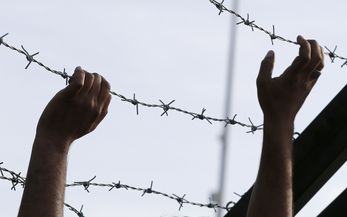 Nach der von ungarischer Seite beschlossene Abriegelung des Grenzuebergangs Horgos-Roeszke lagern die zumeist aus Syrien, Irak und Afghanistan kommenden Fluechtlinge im Niemandsland. Viele der Fluechtlinge demonstrieren gegen Schliessung der Grenze. Foto: Fluechtlinge lassen sich in ihrem Protest vom Stacheldrahtverhau der urgarischen Grenzanlage nicht abhalten.