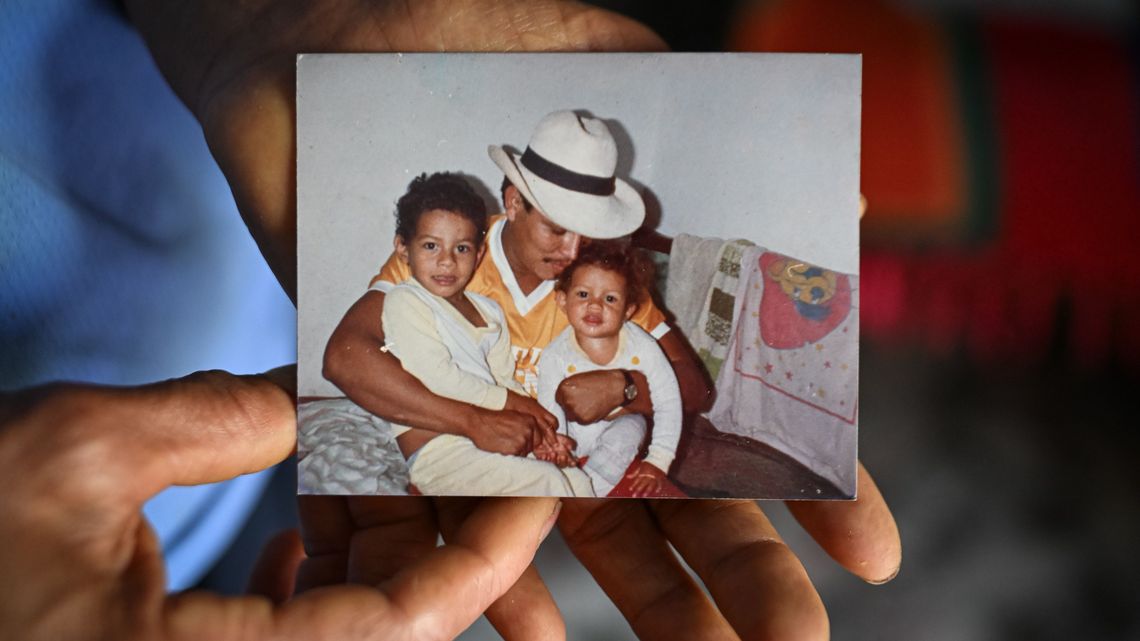 Martha Berrío zeigt ein altes Foto, auf dem ihr verstorbener Mann mit zwei ihrer Kinder zu sehen ist.