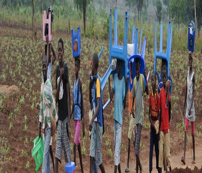 In Angola tragen Kinder Plastikstühle auf dem Weg zur Schule