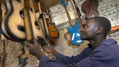 Ein ehemaliger Kindersoldat und jetziger Gitarrenbauer in seiner Werkstatt