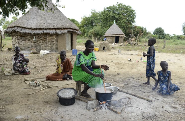 Neues Leben für Kriegsflüchtlinge aus Südsudan AETHIOPIEN, Gambela, Projekte EECMY-DASSC, Ernaehrungssicherung, Region Itang, Dorf Pilual der Ethnie NUER, Fluechtling aus dem Suedsudan Mun Kunen, 36 Jahre, und seine Frau Neelam haben Training und Saatgut zur Anlage eines Gemuesegartens bekommen, Frau Neelam kocht Maisbrei und Aubergine