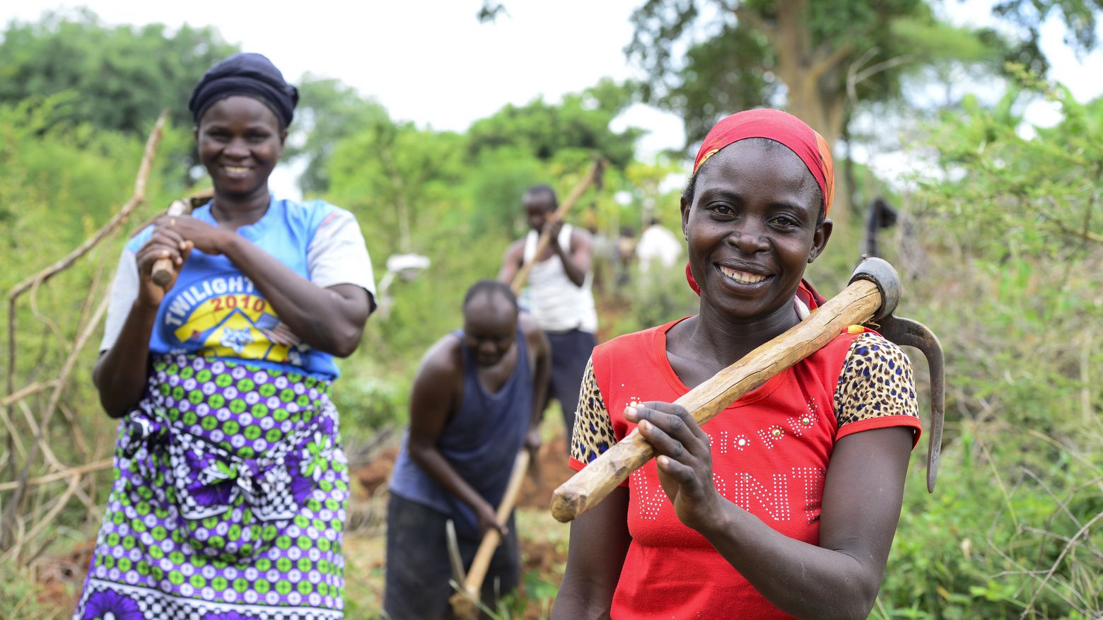 Rural women and men in Kenya digging an irrigation channel