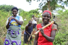 Rural women and men in Kenya digging an irrigation channel