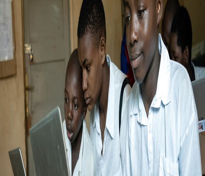 Schüler sitzen an Laptops