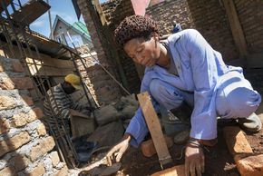 Die Mauerin Esthere Matutina machte im Ausbildungszentrum CAPA in der Demokratischen Republik Kongo eine Maurerlehre. Seither arbeitet sie erfolgreich als Maurerin im Wohnungsbau.