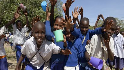 Gruppe von Schulkindern die Plastiktassen in der Hand halten 