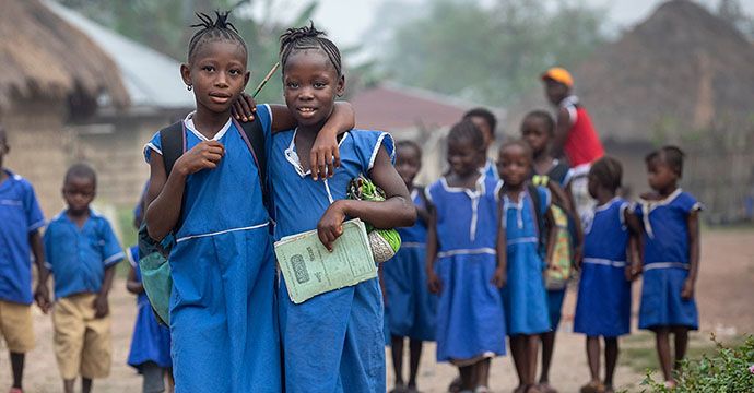 Gemeinsam mit ihrer Freundin Fatmata Sheriff (1. Person v. links, 9 Jahre) geht Mbalu Tarawallie (8 Jahre) allmorgendlich in die Dorfschule. Projektpartner: SIGA (Siera Grassroots Agency)