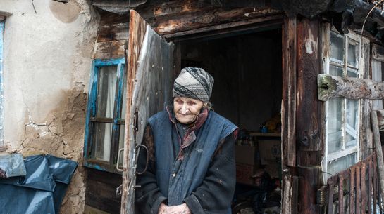 Eine ältere Frau vor ihrem Haus im Dorf Znamenka, das im von pro-russischen Separatisten beherrschten Gebiet liegt