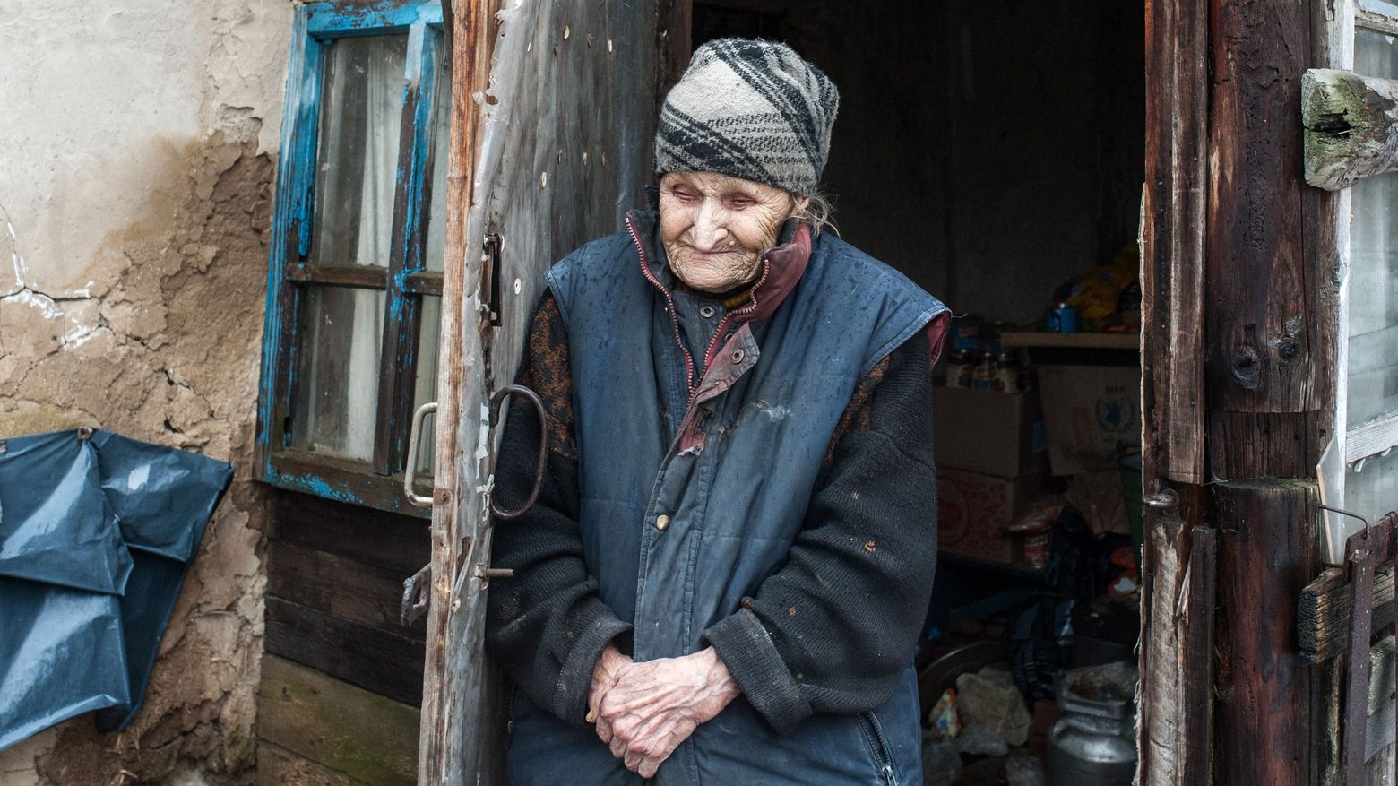 Eine ältere Frau vor ihrem Haus im Dorf Znamenka, das im von pro-russischen Separatisten beherrschten Gebiet liegt